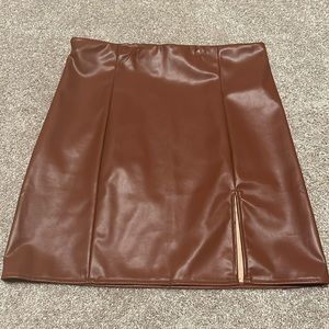 Brown leather mini skirt with slit.